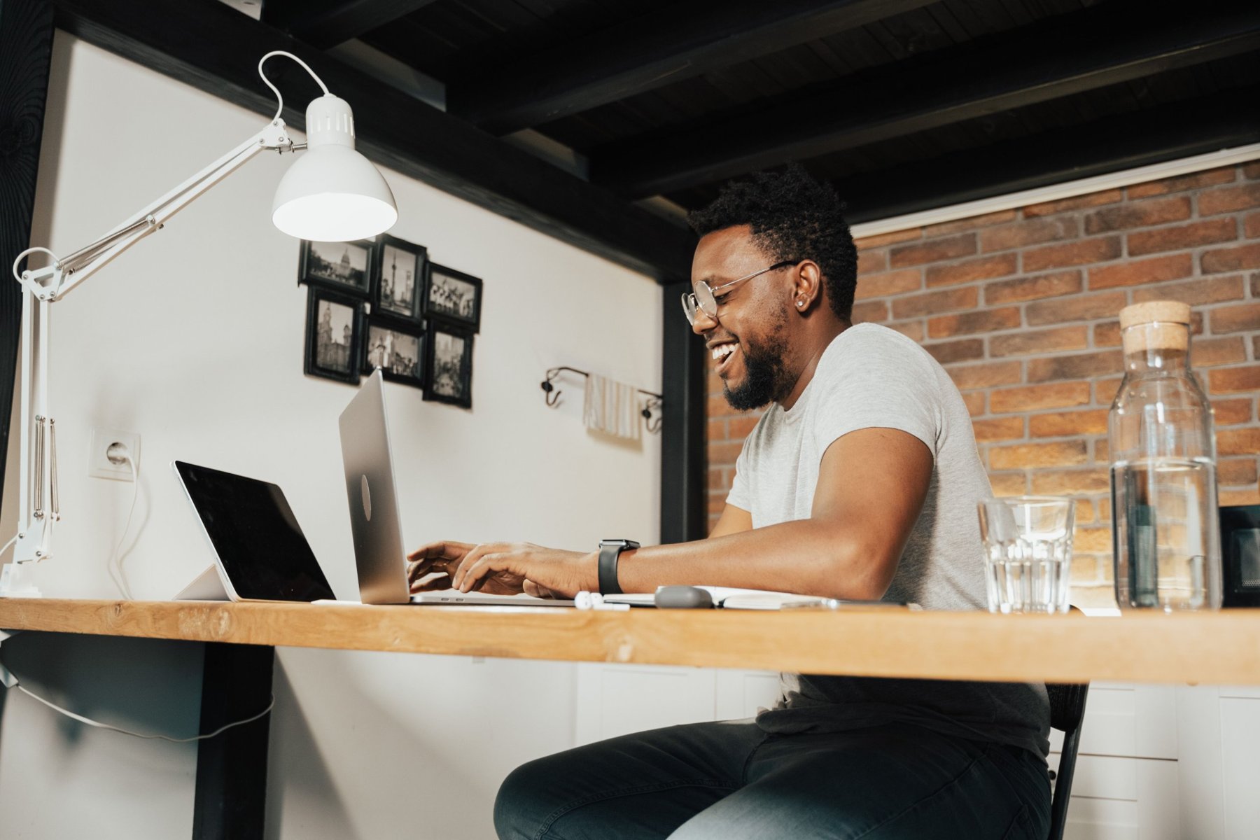 A remote worker smiling at his laptop